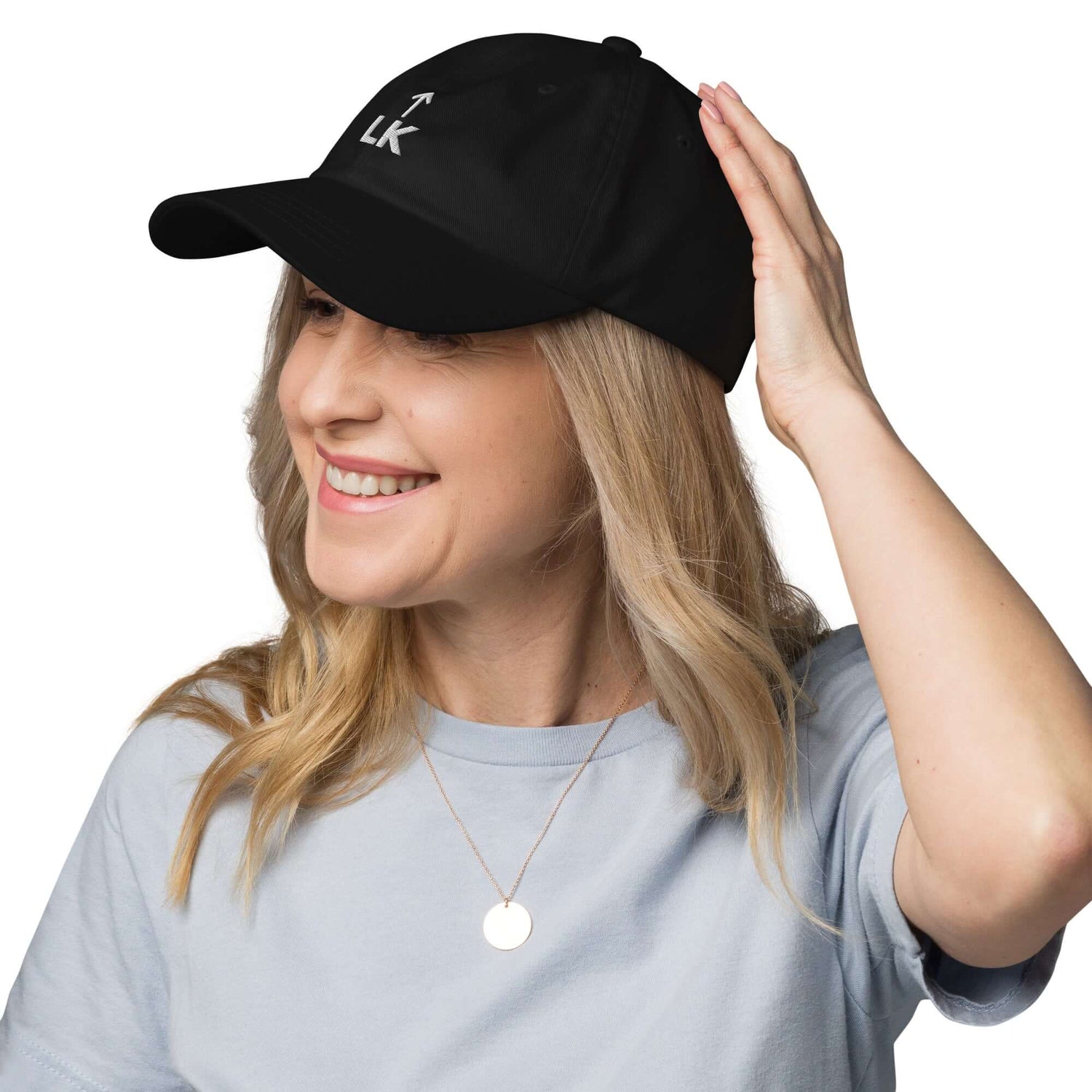A woman wearing a black corner cap jnjdjdnbjnddbnksckn with a subtle lk design, smiling while adjusting her hat.