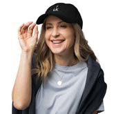 corner cap jnjdjdnbjnddbnksckn worn by a smiling woman, featuring a clean embroidered design on a black cap.