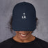 corner cap jnjdjdnbjnddbnksckn featuring LK embroidery on navy cap worn by a smiling person.