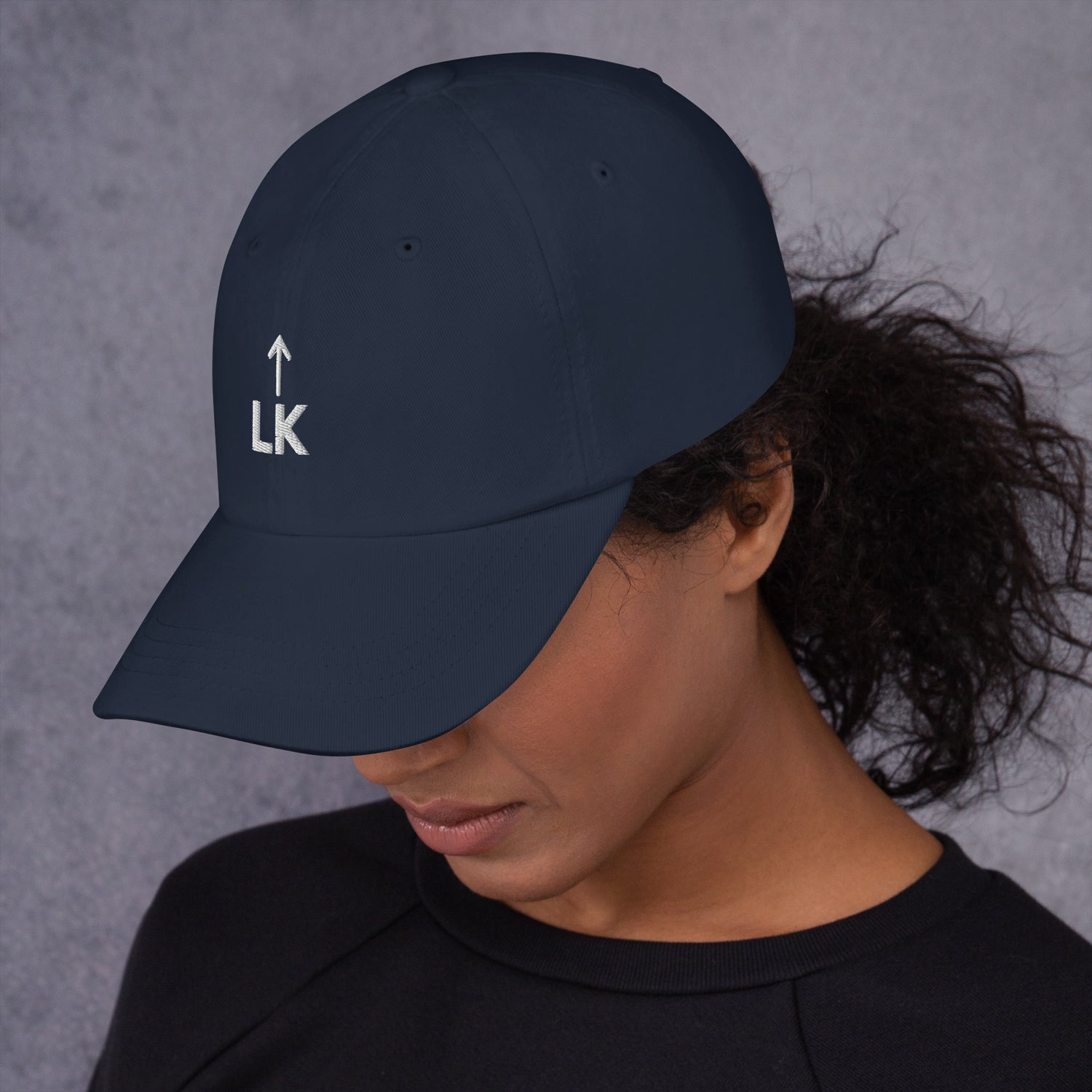woman wearing corner cap jnjdjdnbjnddbnksckn with LK embroidered on front, facing slightly down