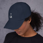 woman wearing corner cap jnjdjdnbjnddbnksckn with LK embroidered on front, facing slightly down